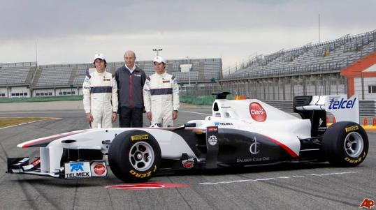 Sergio Perez and Kamui Kobayashi flank team boss, Peter Sauber with the Sauber C30 in front of the trio on a race track.