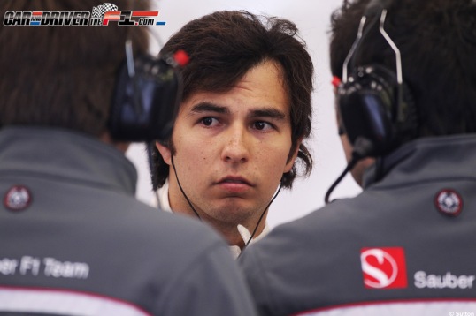 Sauber's Sergio Perez sided by two Sauber pit-crew.